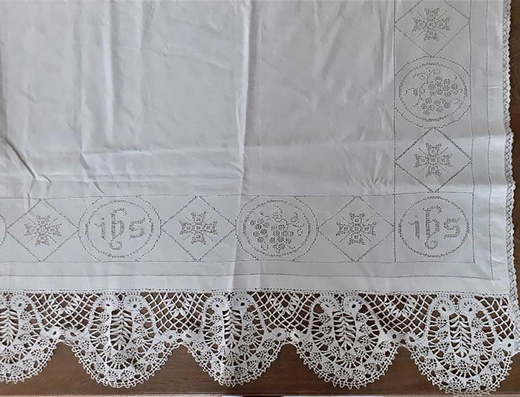 Oltářní textilie s paličkovanou krajkou v kombinaci s bílou dírkovou výšivkou z fary ve Vamberku, přelom 19.–20. století