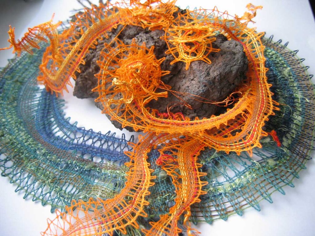 "Pod sopkou", lněná příze, lávový kámen, dřevo, 32×40 cm, paličkovaná krajka, 2019