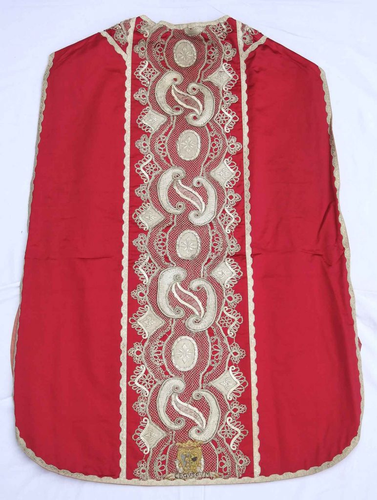 Kněžská kapsule z roku 1730, červená, lemovaná krajkou.