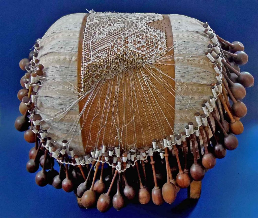 Poduška paličkami a s podvinkem a rozpracovanou válečkovou krajkou